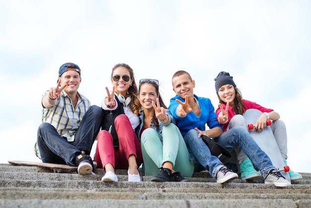 Foto vacanze estive e concetto di adolescente - gruppo di adolescenti che mostrano il gesto del cinque dito
