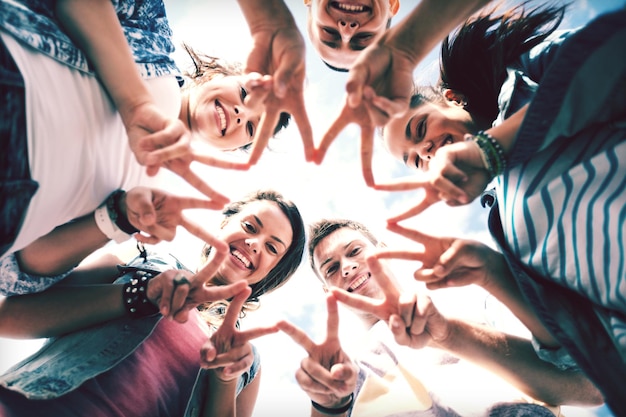 summer holidays and teenage concept - group of teenagers showing finger five gesture