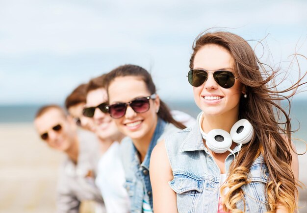 summer holidays and teenage concept - teenage girl with friends outside