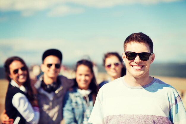 summer holidays and teenage concept - teenager in shades outside with friends