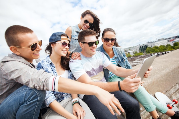 Vacanze estive, concetto di adolescenti e tecnologia - gruppo di adolescenti che guardano un tablet pc