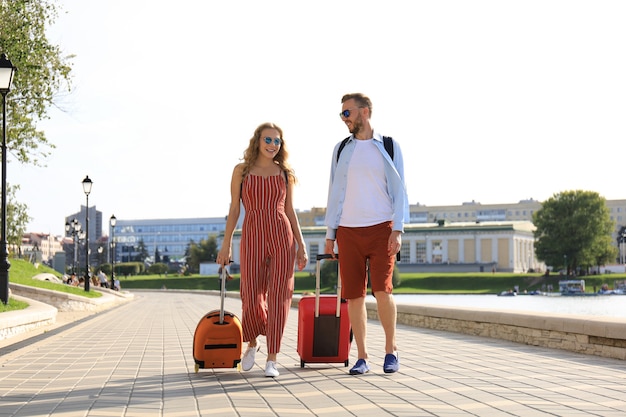 Vacanze estive, concetto di turismo - coppia sorridente con bagagli.