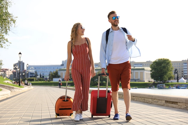 summer holidays, tourism concept - smiling couple with luggage.