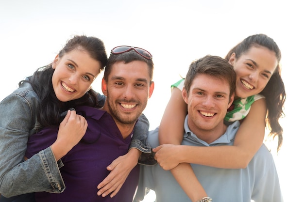 summer holidays, tourism, travel, relations and people concept - group of happy friends having fun outdoors