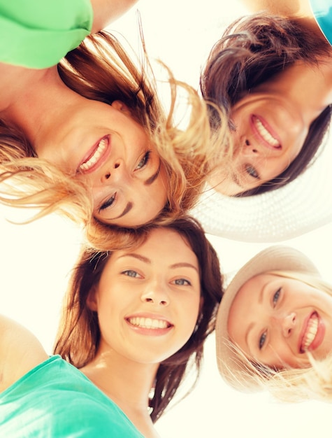 Foto vacanze estive e concetto di vacanza - volti di ragazze che guardano in basso e sorridenti