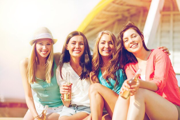 Foto vacanze estive e vacanze - ragazze con bevande sulla spiaggia