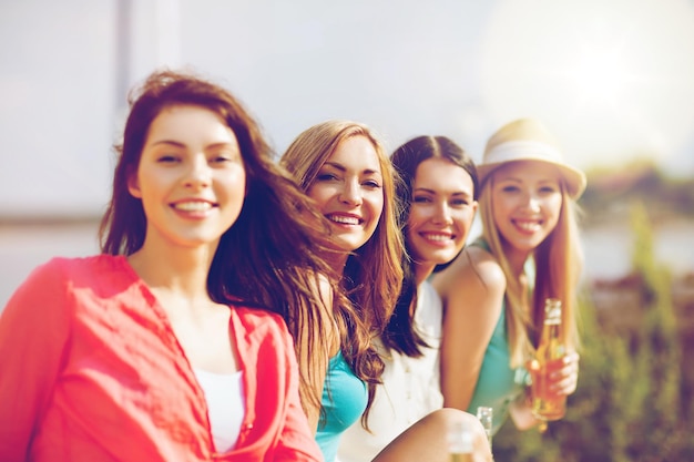 Foto vacanze estive e vacanze - ragazze con bevande sulla spiaggia