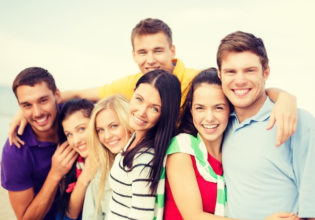 summer, holidays, vacation and happiness concept - group of friends having fun on the beach