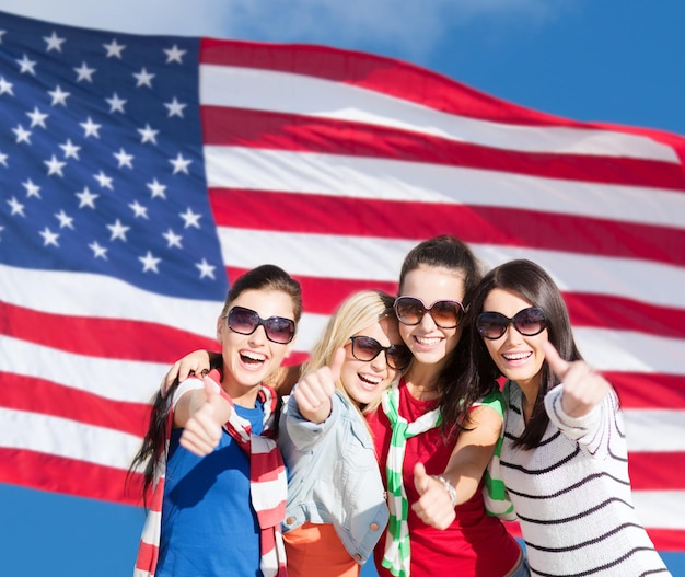 summer, holidays, vacation, happy people concept - beautiful teenage girls or young women showing thumbs up