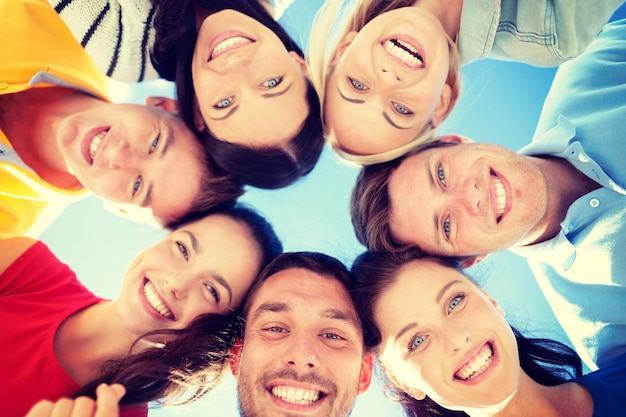 summer, holidays, vacation, happy people concept - group of teenagers looking down