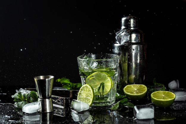 Summer homemade lemonade made from lime lemon cucumber with ice in glass drink with liquid splash freeze motion in jar glass on dark background