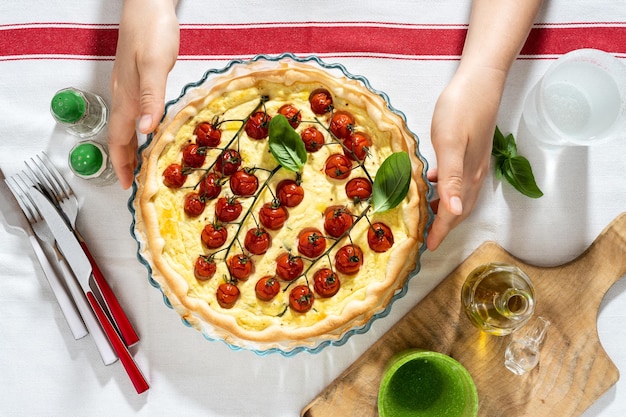 写真 白いテーブル クロスと女性の手でチェリー トマトとリコッタ チーズの夏のイタリアン パイ生地
