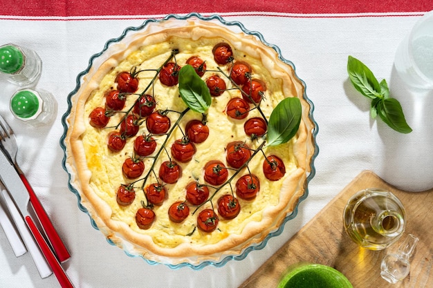 白いテーブル クロスにチェリー トマトとリコッタ チーズの夏のイタリアン パイ生地