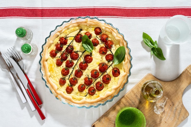 白いテーブル クロスにチェリー トマトとリコッタ チーズの夏のイタリアン パイ生地
