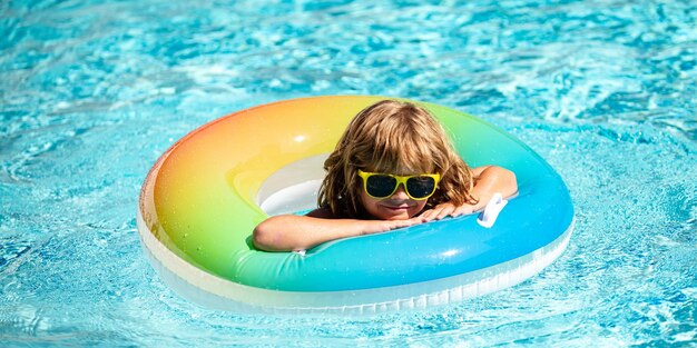 Ragazzo di fine settimana estivo di vacanza estiva per bambini in piscina bambino all'aquapark ragazzo divertente su gonfiabile