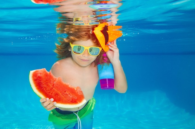 Летний детский портрет в воде бассейна ребенок плавает и ныряет под водой в бассейне