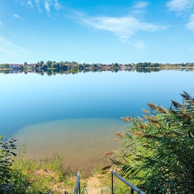 Summer lake calm beach with wood steeps to the water