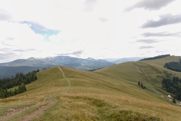 Летний пейзаж в горах и синем небе с облаками. Пейзаж с гор Бучеджи, часть Южных Карпат в Румынии в очень туманный день