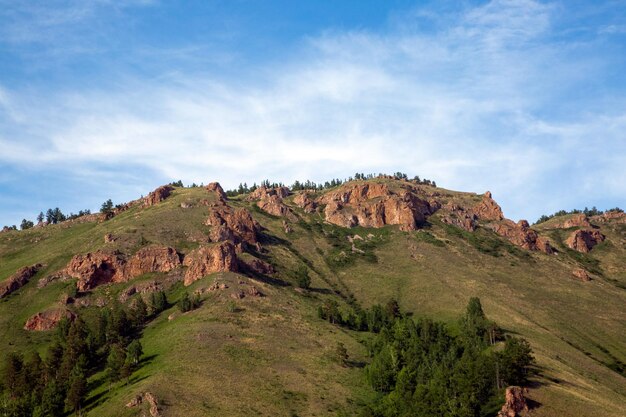 Summer landscape mountains and rocks against a blue sky with clouds with copy space Tourism active recreation