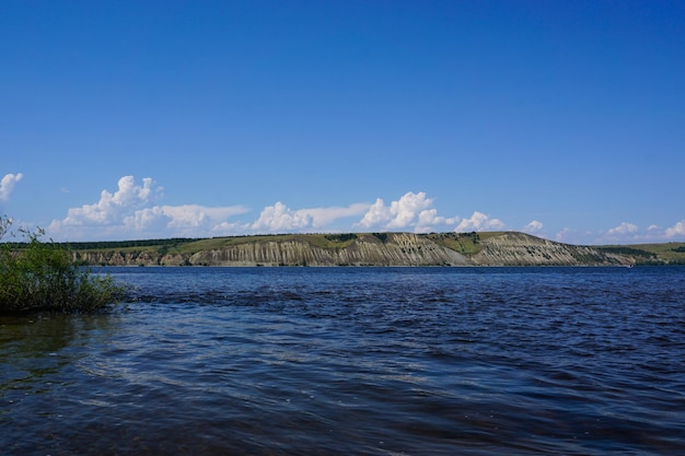 Летний пейзаж на реке с облаками в голубом небе