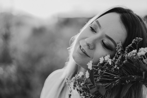 彼の頭に野生の花の花輪の花輪で美しい若い女性の夏のライフスタイルの肖像画