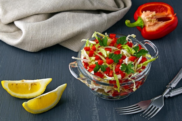 Summer light salad of fresh white cabbage paprika and parsley seasoned with oil and lemon in glass b