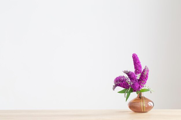 summer lilac in glass vase on wooden shelf