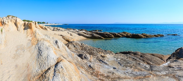 夏の朝の砂浜とプラタニツィビーチ近くの岩の多い海岸シトニア半島ハルキディキギリシャパノラマ人々は認識できない