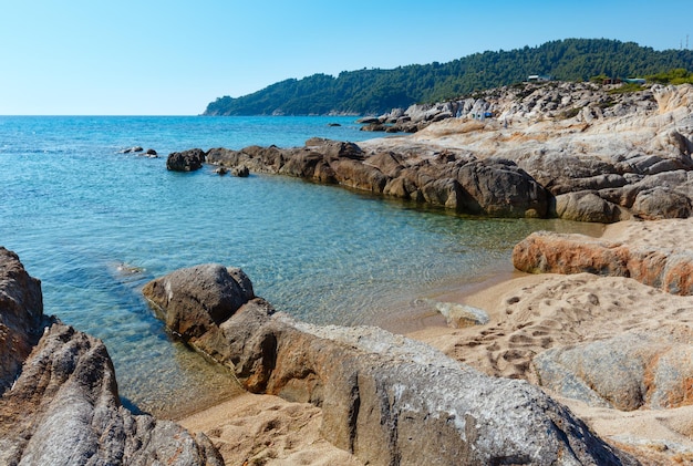 プラタニツィビーチ（シトニア半島、ハルキディキ、ギリシャ）近くの夏の朝の砂浜と岩の多い海岸。