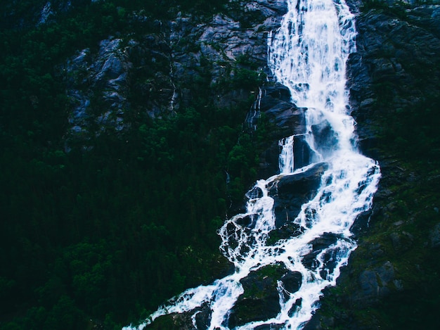 斜面にある夏の山のLangfoss滝（Etne、ノルウェー）。空中写真