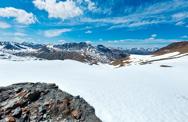 斜面に雪が降るステルヴィオ峠からの夏の山の景色（イタリア）