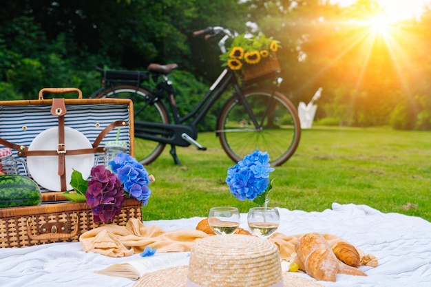 Concetto di picnic estivo in una giornata di sole con bouquet di frutta di anguria, ortensie e fiori di girasoli