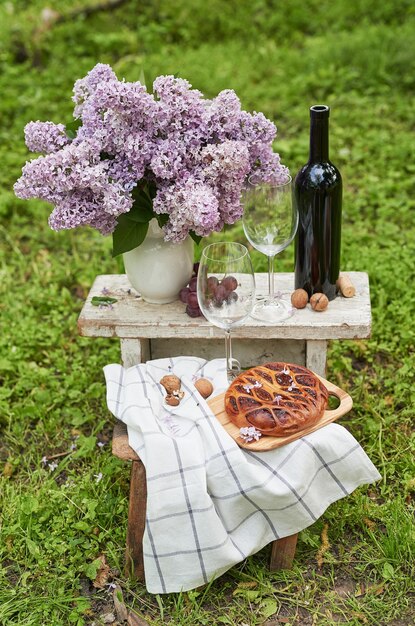 Summer picnic in garden Wine pie fruits and flowers Still life Easter lunch and table