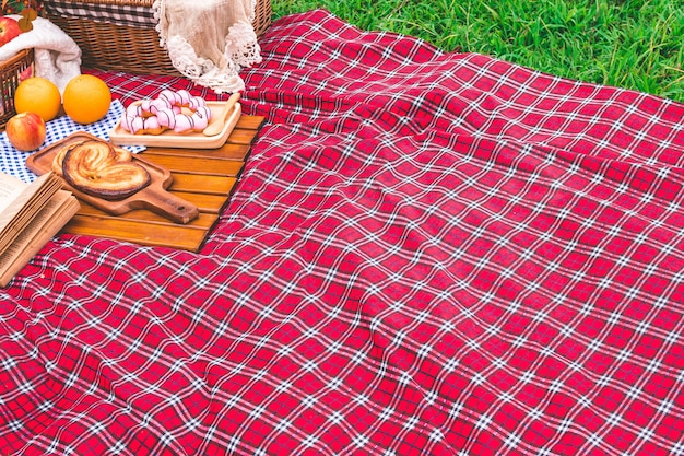 Foto estate picnic con un cesto di cibo sulla coperta nel parco. spazio libero per il testo