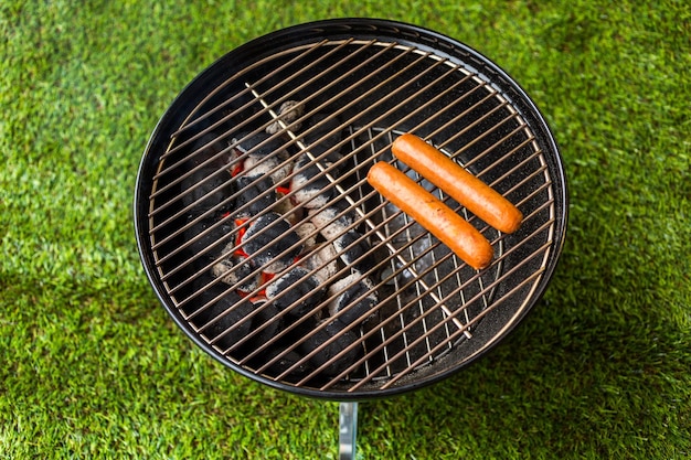 Summer picnic with small charcoal grill in the park.