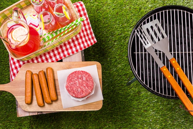 Summer picnic with small charcoal grill in the park.