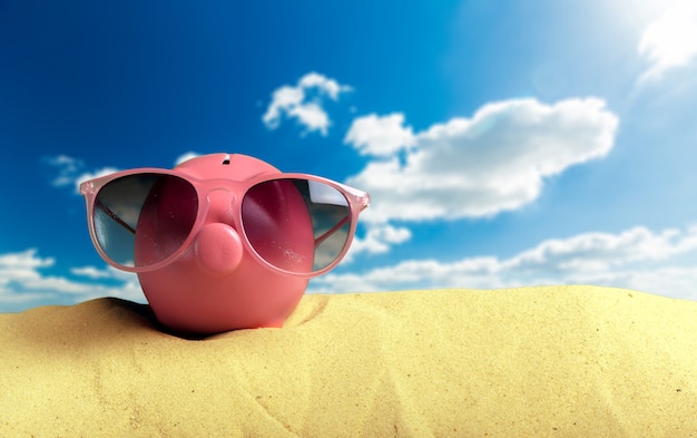 Photo summer piggy bank with sunglasses on the beach