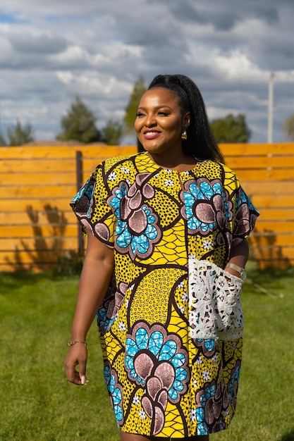 Summer portrait of beautiful african american woman in colourful dress wear standing on backyard Suburban lifestyle and chilling on weekend in countryside and inclusion with diversity concept