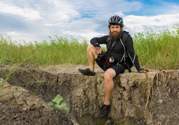 Summer portrait of a cyclist wearing a helmet outdoors Cyclist resting on a halt