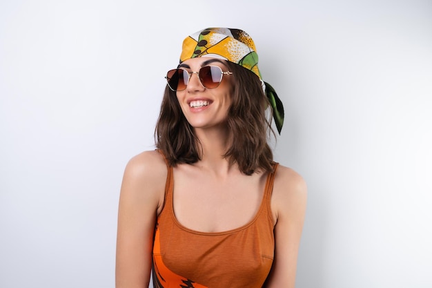 Summer portrait of a young woman in a sports swimsuit headscarf and sunglasses