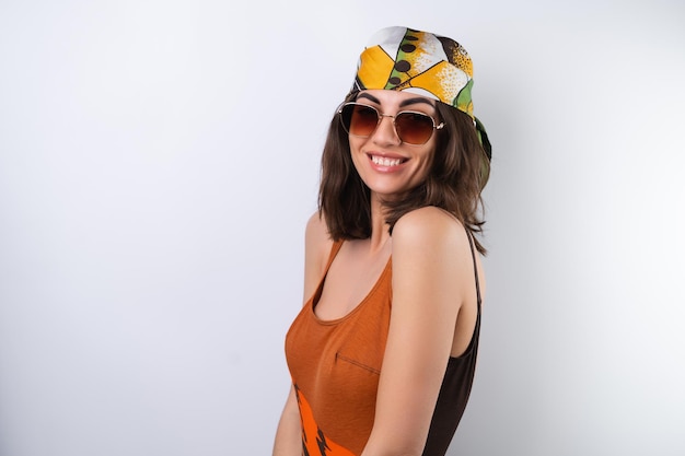 Summer portrait of a young woman in a sports swimsuit headscarf and sunglasses