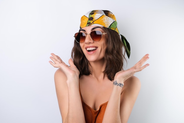 Summer portrait of a young woman in a sports swimsuit headscarf and sunglasses