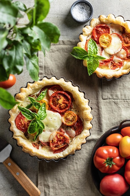 Photo summer puff pastry tart with tomato mozzarella and bazil vegetable quiche flat lay