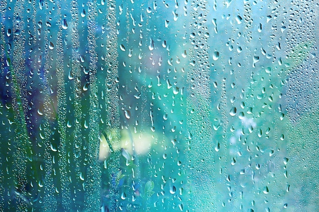 Summer rain wet glass / abstract background landscape on a rainy day outside the window blurred background