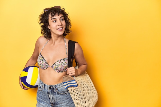 Foto donna pronta per l'estate con abbigliamento da spiaggia e frisbee sullo sfondo giallo dello studio