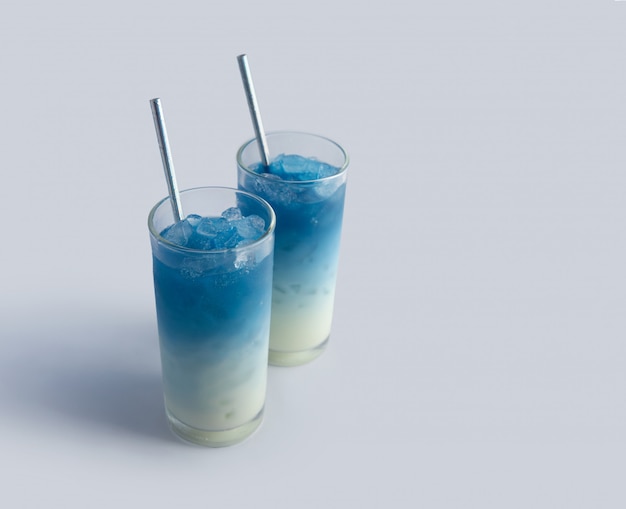 Summer refreshing beverage blue butterfly pea latte in glass on white background