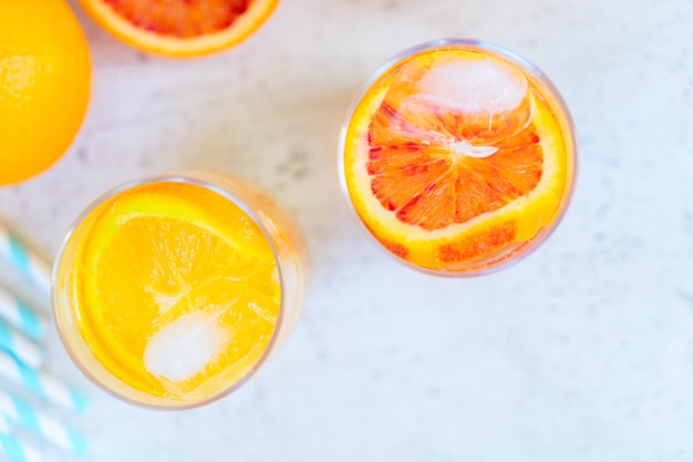 Summer refreshing citrus drinks with ice on white table