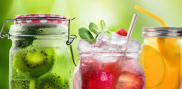 Photo summer refreshing cocktails lemonade made from fresh fruits and berries in glass jars with droplets close-up