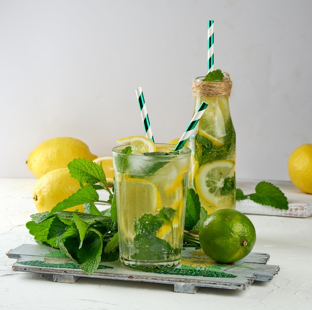 Bevanda rinfrescante estiva limonata con limoni, foglie di menta, lime in un bicchiere