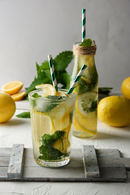 Bevanda rinfrescante estiva limonata con limoni, foglie di menta, lime in un bicchiere